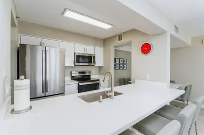 a kitchen with a white counter and a refrigerator at Brickell, Miami Home in the Sky! in Miami