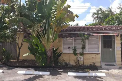 a small house with a palm tree in front of it at 4-PLEX in Fort Lauderdale