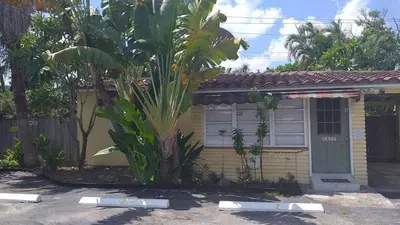 a small house with a palm tree in front of it at 4-PLEX in Fort Lauderdale