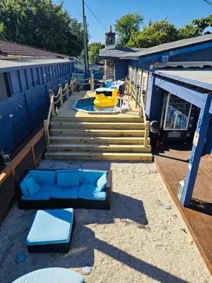 a deck with blue and yellow furniture and stairs at Blue Little Havana in Miami