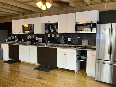a kitchen with white cabinets and a stainless steel refrigerator at Blue Little Havana in Miami