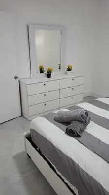 a bedroom with a bed with a dresser and a mirror at Funston in Hollywood
