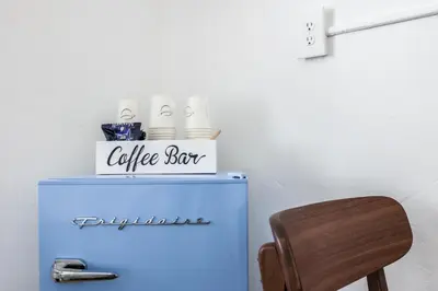 a table and a chair with a coffee box on top of a refrigerator at Starlite Hotel in Miami Beach