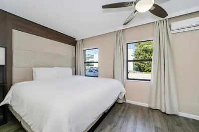 a bedroom with a white bed and a ceiling fan at Deco Boutique Hotel in Fort Lauderdale