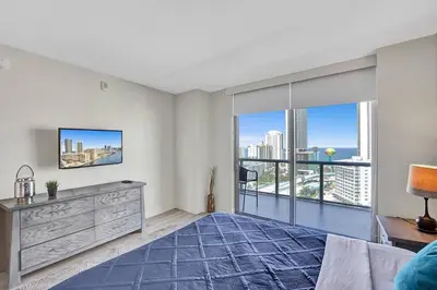 a bedroom with a bed and a large window at Luxury condo with ocean view 4Bedrooms 3Bathrooms in Hallandale Beach