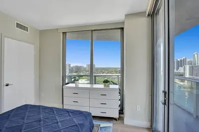 a bedroom with a bed and a large window at Luxury condo with ocean view 4Bedrooms 3Bathrooms in Hallandale Beach