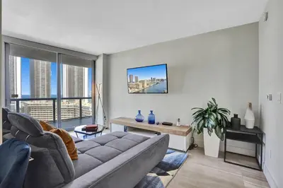 a living room with a couch and a large window at Luxury condo with ocean view 4Bedrooms 3Bathrooms in Hallandale Beach