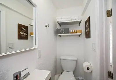 a white bathroom with a toilet and a mirror at Enjoy and relax around Fort Lauderdale area!! in Fort Lauderdale