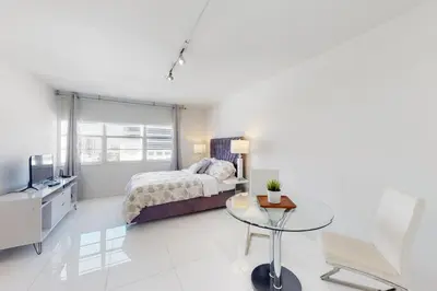 a bedroom with a bed and a glass table at Decoplage Paradise - Main Home in Miami Beach