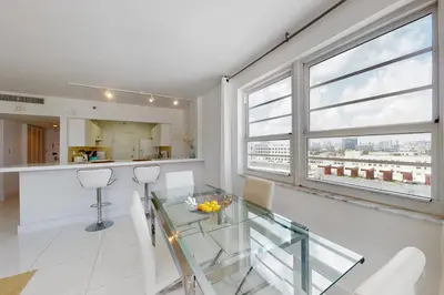a kitchen and dining room with a glass table at Decoplage Paradise - Main Home in Miami Beach