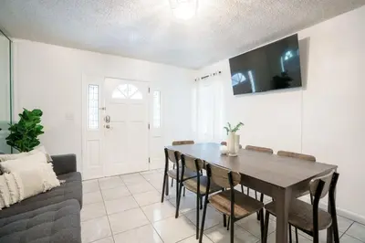 a living room with a dining room table and a couch at Modern 3-Bedroom in the Heart of Wynwood Art District in Miami