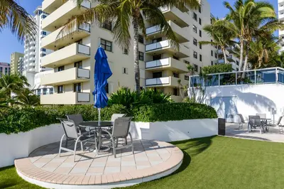 a patio with a table and chairs in front of a building at Decoplage Paradise - Unit A in Miami Beach