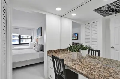 a white bedroom with a bed in the background at Cozy Beachfront 2 BDR & 2 BA Miami Beach Condo in Miami Beach