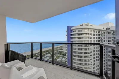 a balcony with a view of a building and the ocean at Cozy Beachfront 2 BDR & 2 BA Miami Beach Condo in Miami Beach