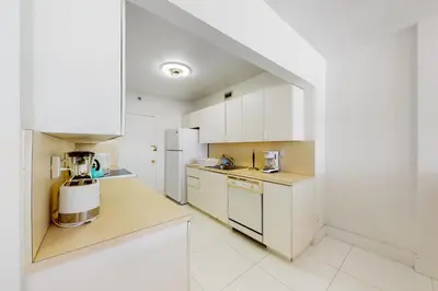 a kitchen with white cabinets and a blender on the counter at Decoplage Paradise - Unit B in Miami Beach