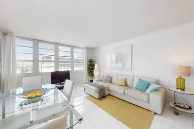 a living room with a couch and a glass table at Decoplage Paradise - Unit B in Miami Beach