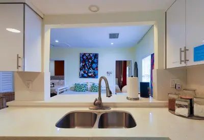 a kitchen with a sink and a living room at Artful 3BR Oasis in Little Haiti, Miami in Miami