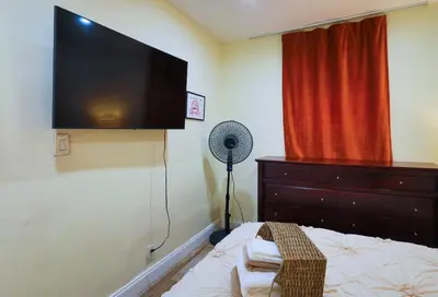 a bedroom with a bed with a flat screen tv on the wall at Artful 3BR Oasis in Little Haiti, Miami in Miami