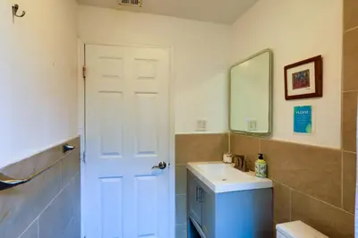 a bathroom with a white door and a sink at Artful 3BR Oasis in Little Haiti, Miami in Miami