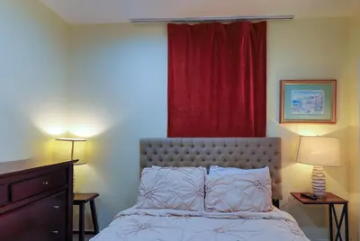 a bedroom with a bed and a red curtain at Artful 3BR Oasis in Little Haiti, Miami in Miami