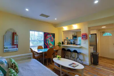 a living room with a table and chairs and a kitchen at Artful 3BR Oasis in Little Haiti, Miami in Miami