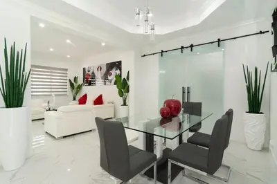 a dining room with a glass table and chairs at The tropical paradise villa in Miami