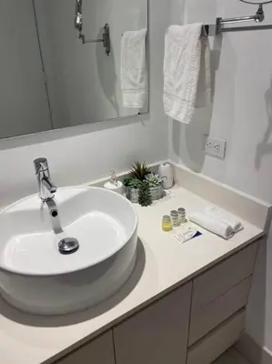 a white bathroom with a sink and a mirror at Beachfront hotel room to relax and unwind 09B in Hallandale Beach