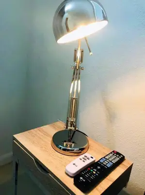 a table with a lamp and two remote controls on it at LOCATION! Apartment in Coconut Grove with parking in Miami