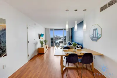 a dining room and living room with a table and chairs at Apartment with Balcony, Gym, Pool in Hallandale Beach