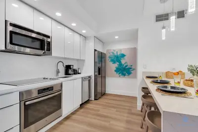a kitchen with white cabinets and a counter top at Pool Apartment with Balcony, Near Beach in Hallandale Beach