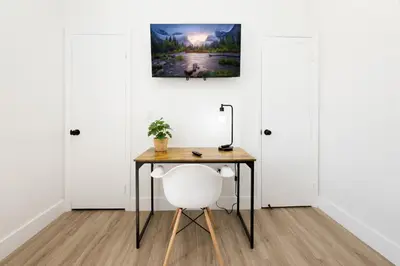 a desk and a chair in a room with white walls at 3 BR Smart home, close to airport, Fast WiFi, Patio, Grill & Free private parking in Miami