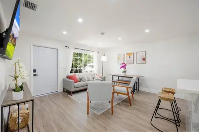 a living room with a couch and a table at 3 BR Smart home, close to airport, Fast WiFi, Patio, Grill & Free private parking in Miami