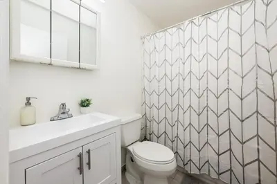 a white bathroom with a toilet and a sink at 3 BR Smart home, close to airport, Fast WiFi, Patio, Grill & Free private parking in Miami
