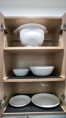 a shelf with white bowls and plates in a cabinet at Stylish Studio Near Wynwood & Design District in Miami