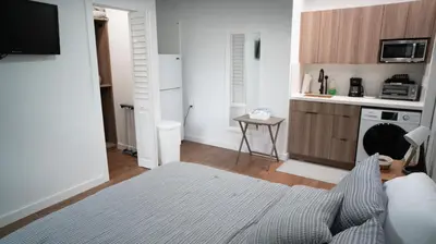 a living room with a bed and a kitchen at Stylish Studio Near Wynwood & Design District in Miami