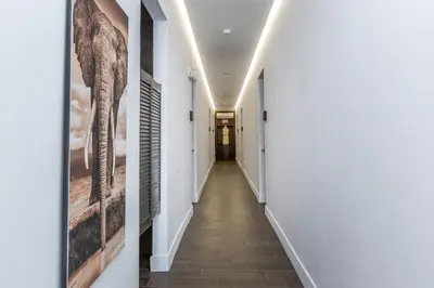 a corridor in a house with white walls and a long hallway at Vive Zen Master Suite for 4 Guests in Miami