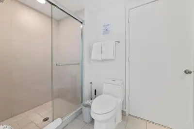 a bathroom with a toilet and a glass shower at The Ultimate Resort - BEACHFRONT 2 BEDROOM APARTMENT WITH DIRECT OCEAN VIEW, ROOFTOP POOL, HOT TUB AND GYM in Hollywood