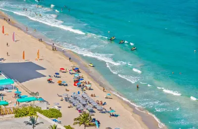 an overhead view of a beach with people in the ocean at The Ultimate Resort - BEACHFRONT 2 BEDROOM APARTMENT WITH DIRECT OCEAN VIEW, ROOFTOP POOL, HOT TUB AND GYM in Hollywood