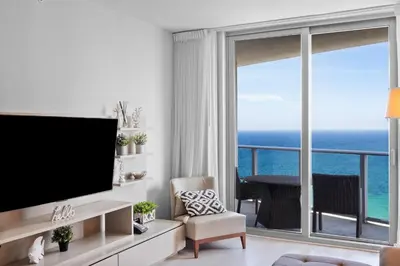 a living room with a television and a view of the ocean at Picturesque Beachfront Condo - LOVELY 2BD and 2BA APT WITH DIRECT OCEAN VIEW in Hollywood