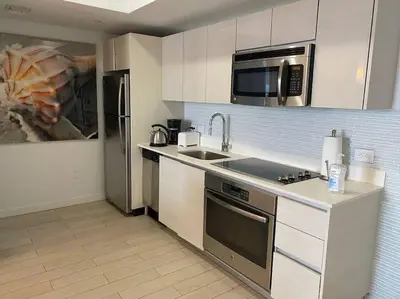 a kitchen with a stainless steel refrigerator and a microwave at Dream Beach Apt 1BR Kitchen & Pool Access 06A in Hallandale Beach