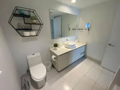 a bathroom with a toilet and a sink and a mirror at Dream Beach Apt 1BR Kitchen & Pool Access 06A in Hallandale Beach