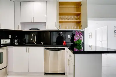a kitchen with white cabinets and a vase of flowers at Hollywood Home w Pool Jacuzzi BBQ and Pool Table in Hollywood