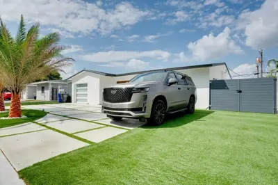 a white suv parked in front of a house at Hollywood Home w Pool Jacuzzi BBQ and Pool Table in Hollywood