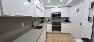 a kitchen with white cabinets and stainless steel appliances at NEW LUXURY APARTMENT 2Br 2Ba DIRECT BEACH ACCESS in Hollywood Beach
