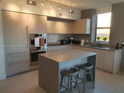 a kitchen with a island with two bar stools at Lux apartment Hyde Beach House in Hollywood