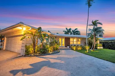a house with palm trees and a driveway at 180 of Waterfront Heated Pool Walk To Beach Paradise Point Key RESIDENCES in Fort Lauderdale