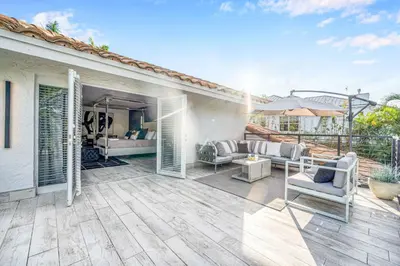 an outdoor patio with chairs and a couch at Waterfront Villa Walk to Beach Venice of America Coastal Extravagance Palm Key VlLLAS in Fort Lauderdale