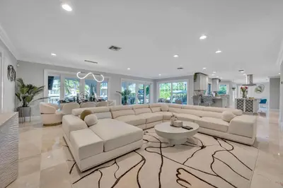 a living room with a large couch and a table at Waterfront Villa Walk to Beach Venice of America Coastal Extravagance Palm Key VlLLAS in Fort Lauderdale