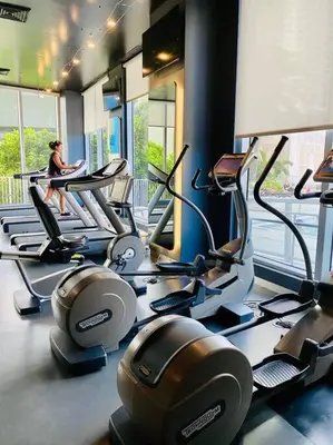 a woman sitting on a treadmill in a gym at Cozy & Comfortable 1BR Apt in Miami Beach 2804A in Hallandale Beach