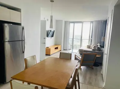 a kitchen and living room with a table and a refrigerator at Cozy & Comfortable 1BR Apt in Miami Beach 2804A in Hallandale Beach